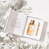 Sunset Hour Holiday Gift Set with Eau de Parfum and travel spray in an elegant white box surrounded by dried flowers